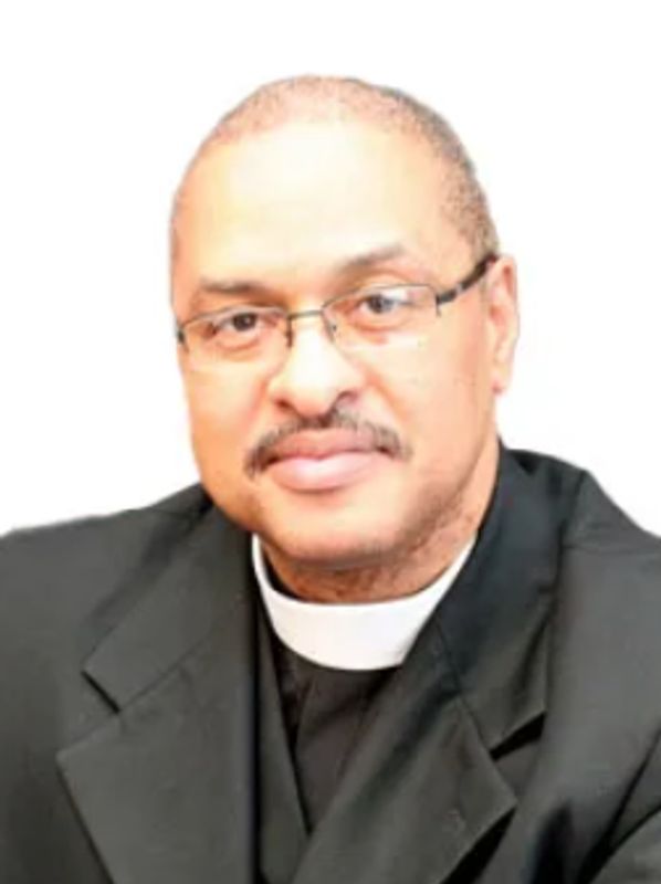 Portrait of a man wearing glasses and a clerical collar.