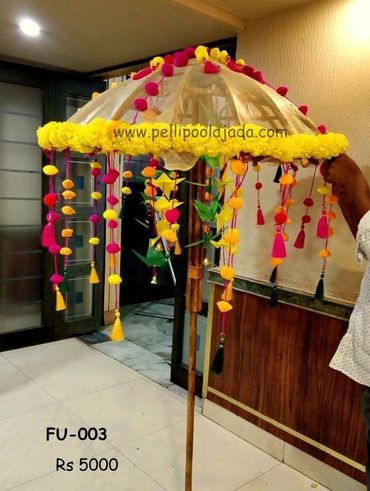 Pellipoolajada_FLoralUmbrella_Vijayawada: Palm leaf parrot umbrella with pom poms for wedding 