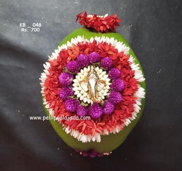 Pellipoolajada_KobbariBondam_Mumbai:  design with ganesh motif surrounded with multicolor flowers
