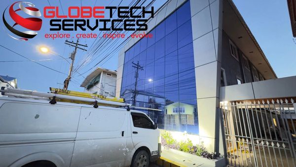 Modern building with reflective glass and a white van outside.