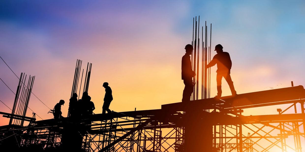 Silhouette engineer standing orders for construction crews to work on high ground heavy industry