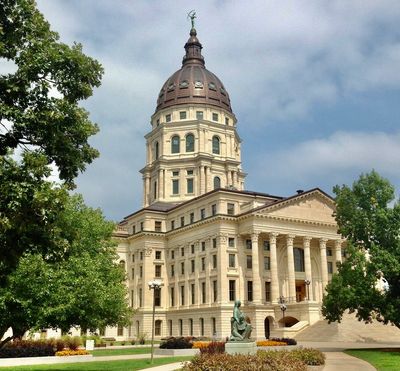 Historic government building with a dome and statue.