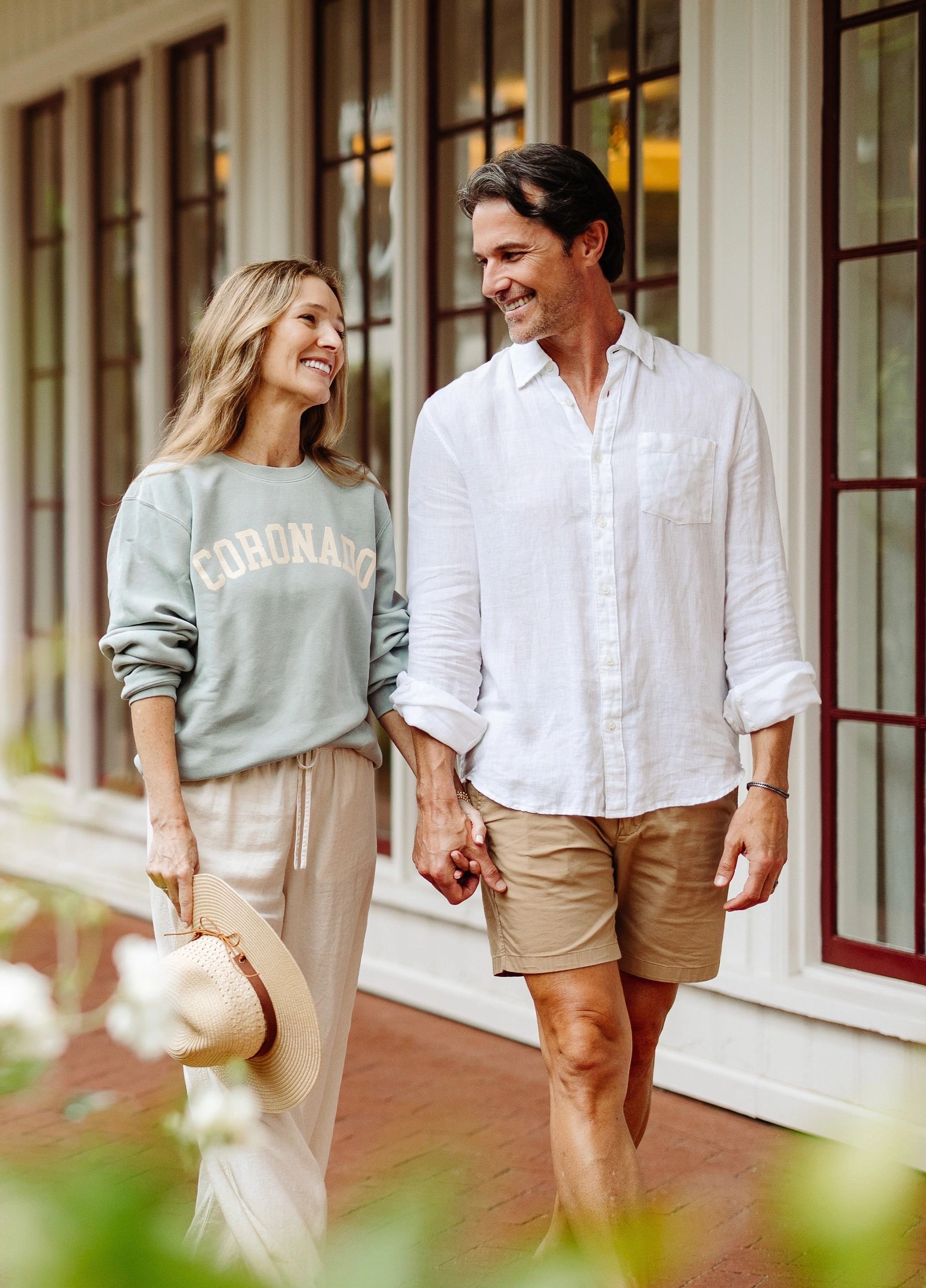 Couple holding hands and smiling at each other.