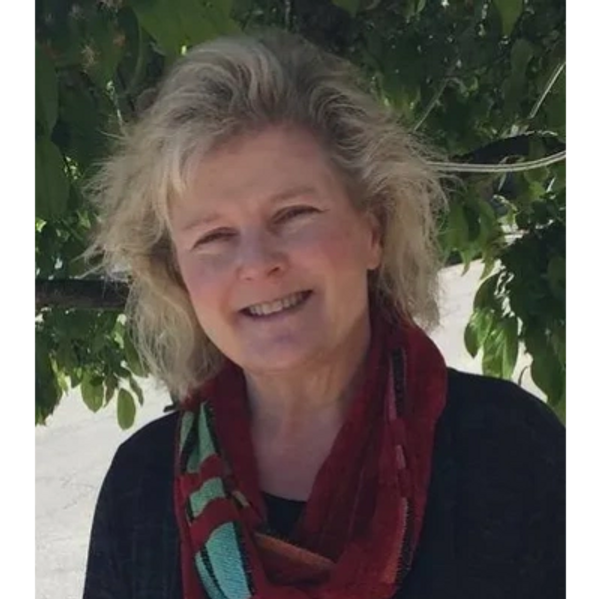 Smiling woman outdoors wearing a colorful scarf.