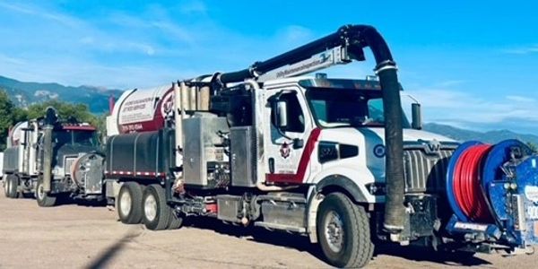 Large industrial vacuum truck under blue sky.