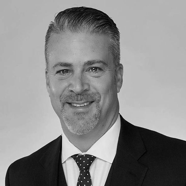 Smiling man in a suit and tie.
