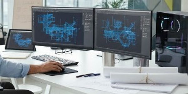 Person working on architectural or engineering blueprints on multiple monitors.