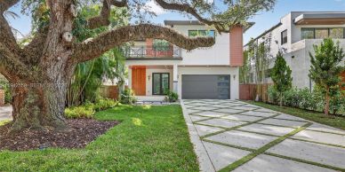 Modern two-story house with a large tree in front.