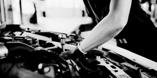 Automotive Mechanic holding a torque wrench under the hood of a car