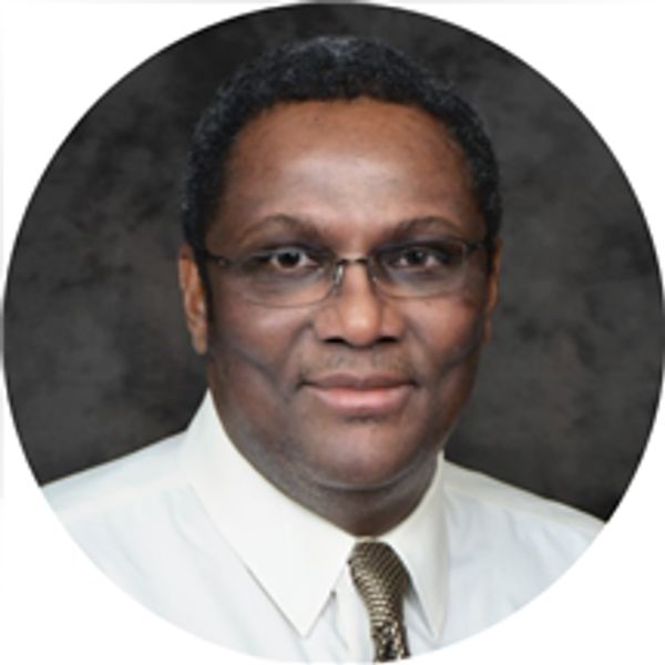 Portrait of a man with glasses in formal attire.