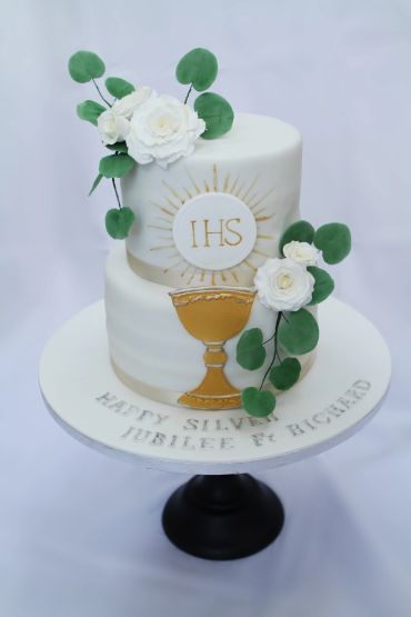 Elegant two-tier cake with white flowers and gold chalice design.