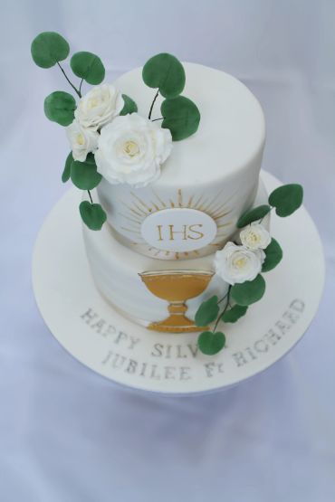 Elegant two-tier cake with white flowers and gold chalice design.