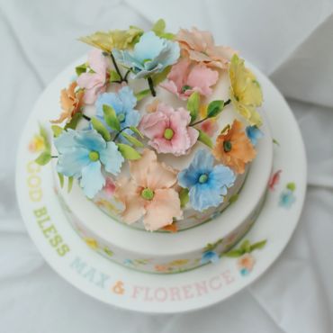 Two-tiered cake decorated with pastel floral icing.