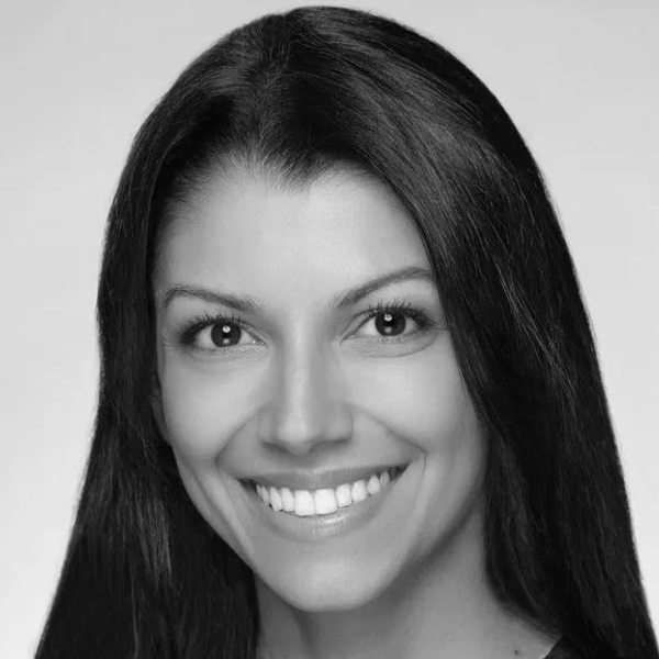 Smiling woman with long straight hair in a black-and-white portrait.