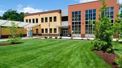 Modern building with large windows and a well-maintained lawn.