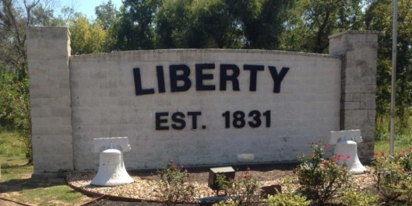 A stone sign reading 'LIBERTY EST. 1831' surrounded by greenery.