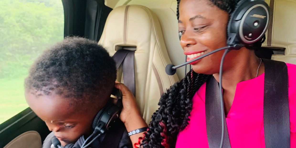 Woman and boy wearing headsets in a vehicle, sharing a joyful moment.