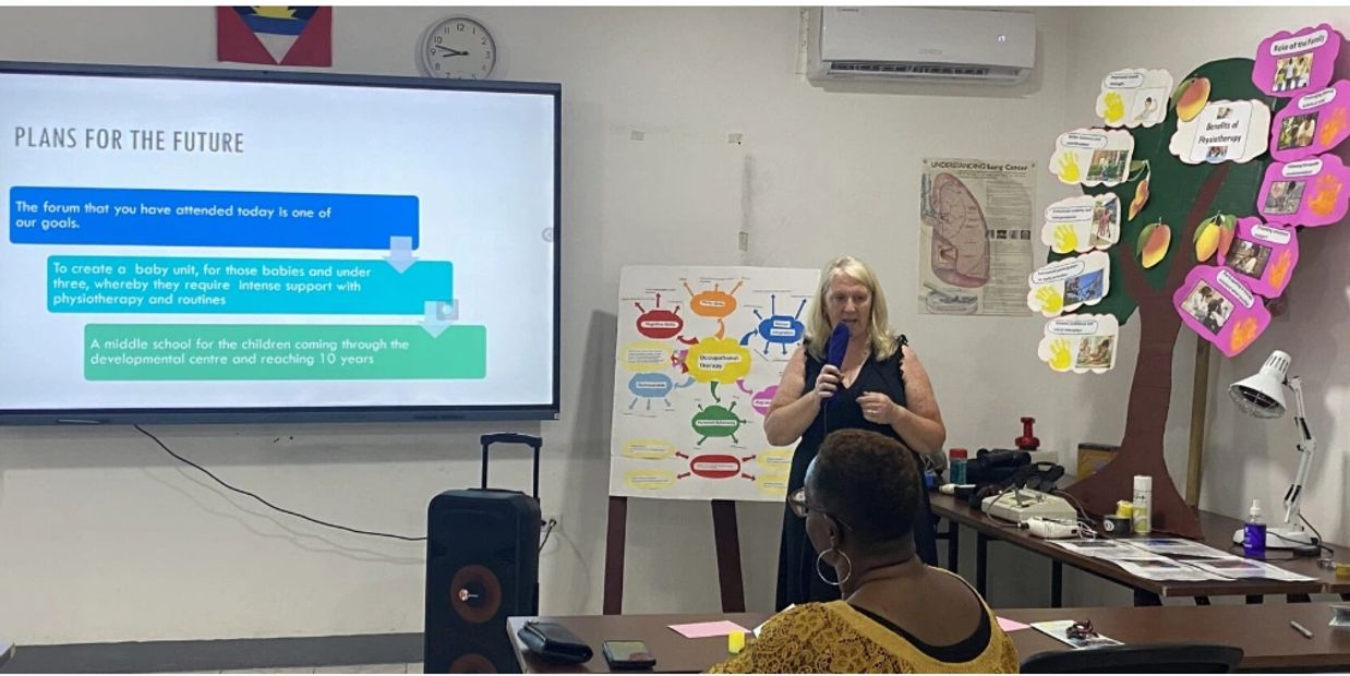 Woman giving a presentation in a classroom setting.