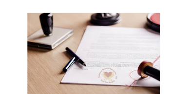 A document with a pen and a seal on a wooden desk.