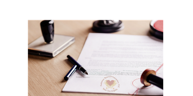 A document with a pen and a seal on a wooden desk.