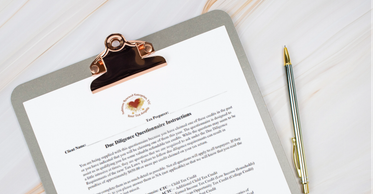 A clipboard holds a printed questionnaire with a pen beside it on a wooden surface.