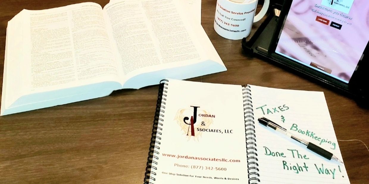 picture of desk with tax book, jordan and associates, llc notebook, jordan and associates, llc coffe