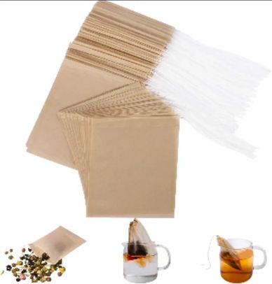 Brown paper tea bags with white strings and tea inside.