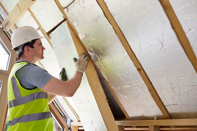 Atlanta GA Kitchen and Bathroom remodeling company worker placing insulation material.