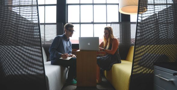 people laptop office desk couches lamp windows