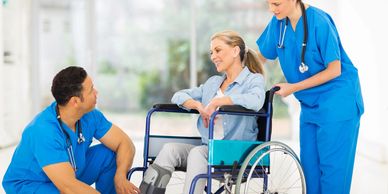 Two nurses talking with a woman in a wheelchair about disability plans