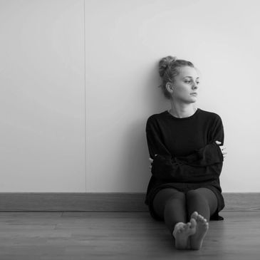 A woman sitting against a wall