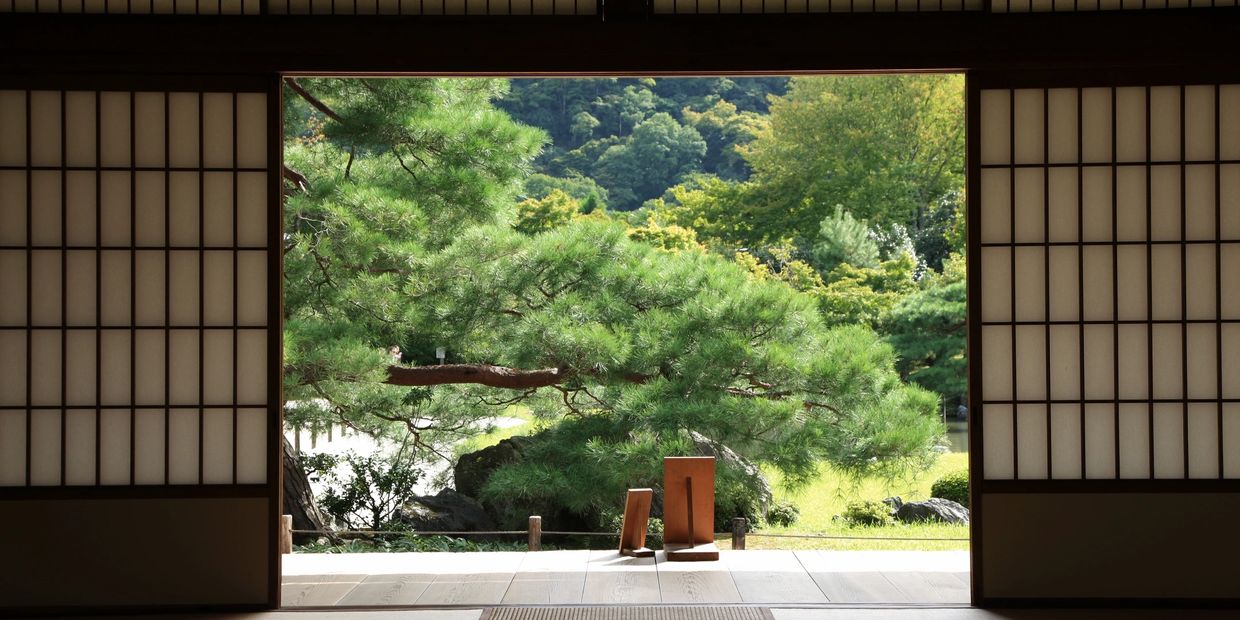 Traditional Japanese room with sliding doors opening to a lush garden view.