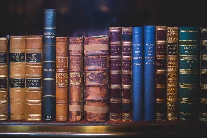 A series of old books on a shelf