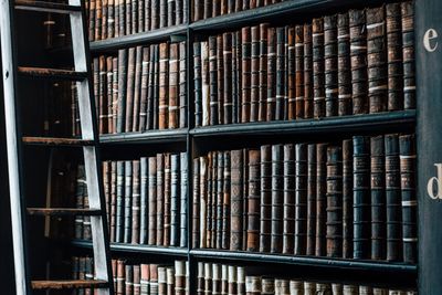 Bookcase filled with book with ladder to climb