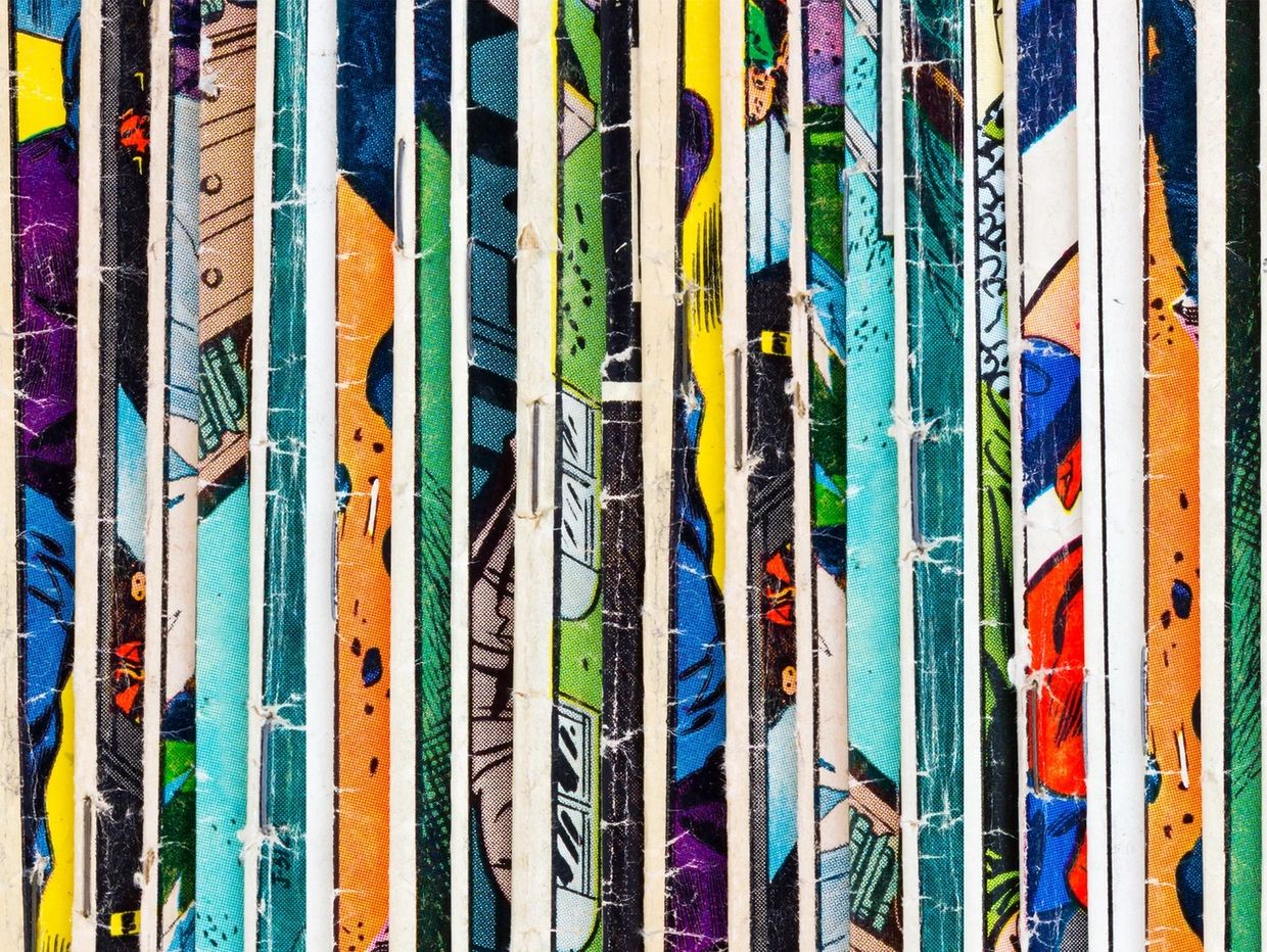Stack of comic book spines showing colorful artwork.