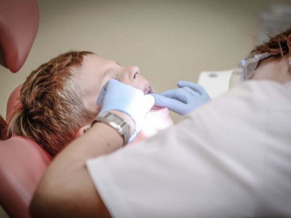 Child receiving dental care from a dentist.