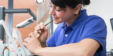 A woman learning how to become a dental nurse at college.