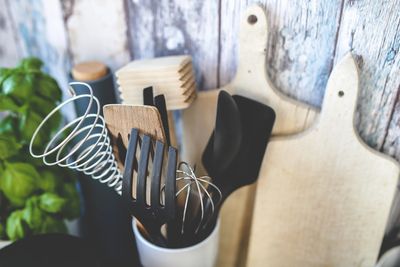 A container holding various kitchen utensils, including whisks and spatulas.