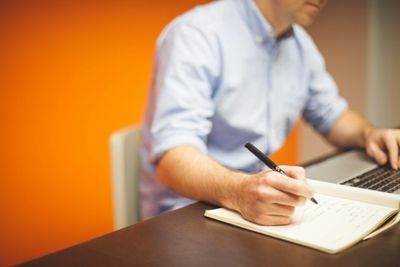 man at laptop with notebook