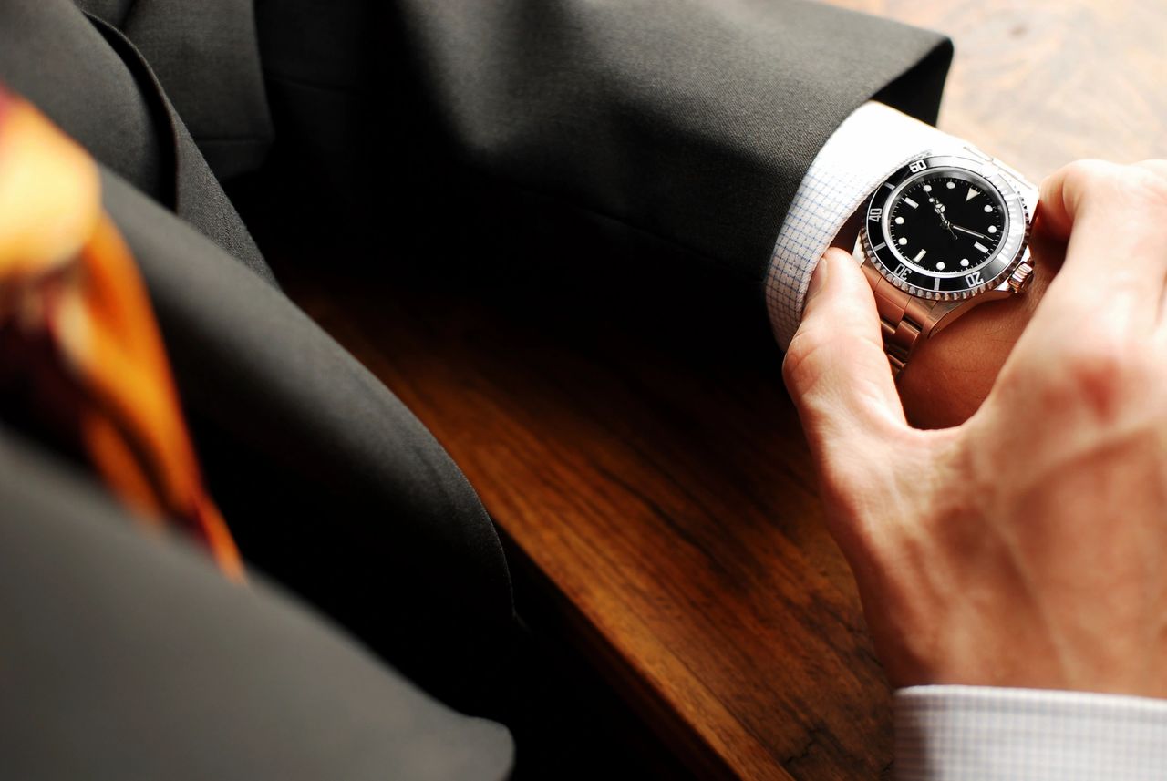 An investor checks his watch to make sure he is on time.