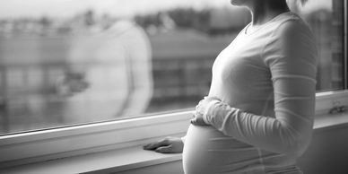 Pregnant woman looking out the window.