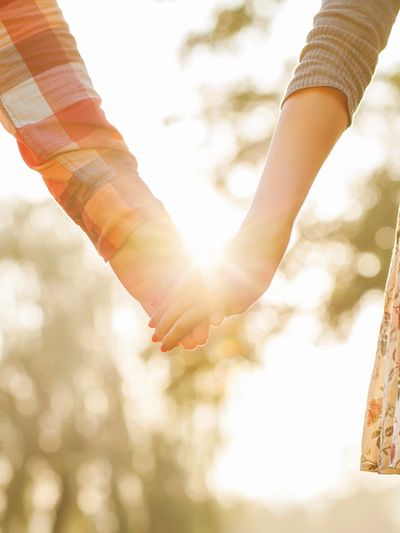 Sunlight shining through interlocked hands