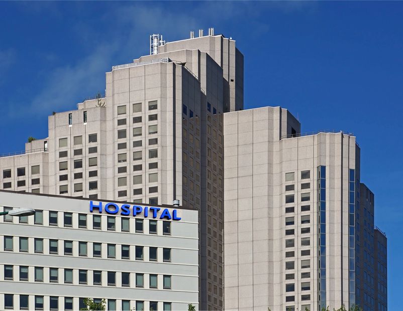 Modern hospital building under clear blue sky.