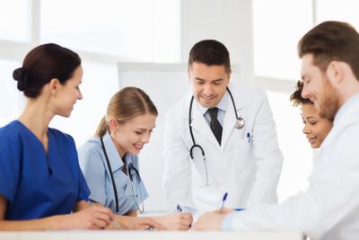 Group of health care workers discussing patient care.