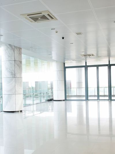 Bright and spacious modern lobby with marble pillars and large glass doors.