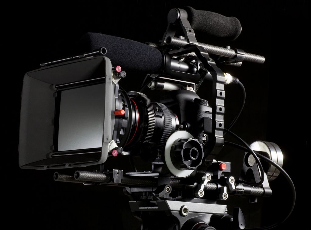 Professional video camera with microphone and accessories.