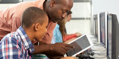 Teacher helping a student understand content on a tablet