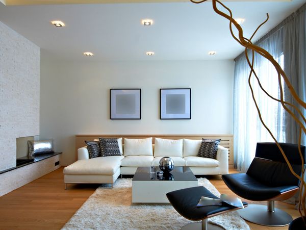 Modern living room with white sofa, black chairs, and minimalist decor.