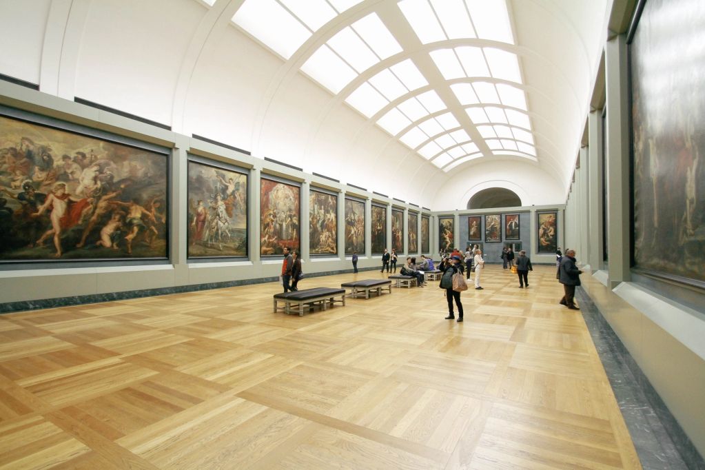 Art gallery with visitors and large paintings.