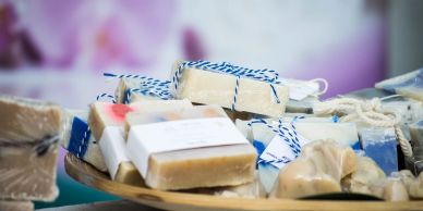 Assorted handmade soaps displayed on a wooden tray.